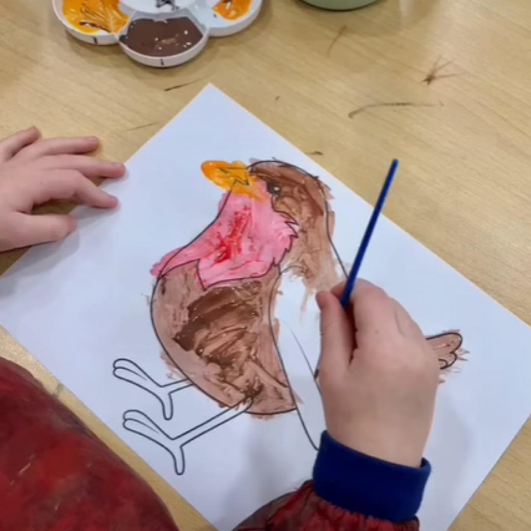preschool child painting a robin