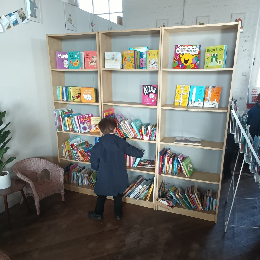 A pupil looking at books at The Reading Tree